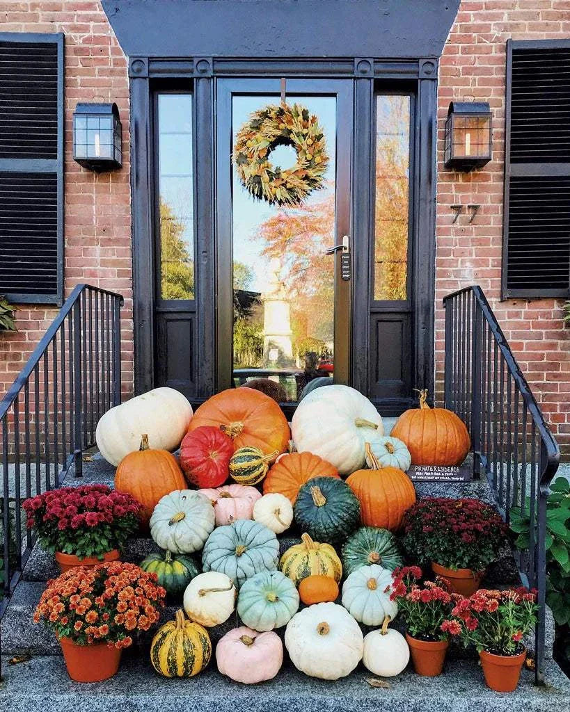 Front porch decorated with a variety of pumpkins, gourds, hay bale, mums, and an autumn wreath for the Premium Porch Package